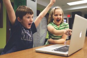 Children cheering behind a laptop screen