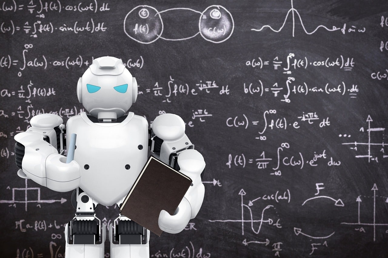A white robot stood in front of a blackboard